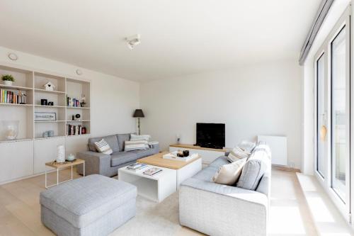 uma sala de estar com dois sofás e uma televisão em B&B Le Murmure de l'eau - Chambre d'hôte Urbaine - Namur em Namur