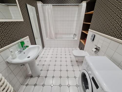 a white bathroom with a sink and a toilet at Fantastic Apartments - OK11 Room - C in Warsaw