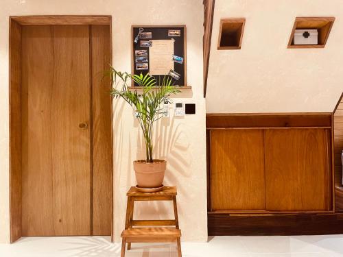 a potted plant sitting on a stool next to a door at Dongbok Sanjang Jeju in Jeju