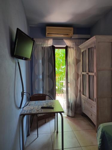 a room with a table with a television and a window at HOTEL PASTERAL RIU TER in La Cellera de Ter