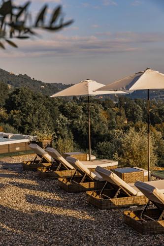 a row of lounge chairs and umbrellas at Villa Antica Colonia SPA & Wellness in Pettenasco