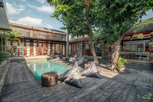 una persona sentada junto a una piscina en una casa en Batu Belig Living Apartment Seminyak, en Seminyak