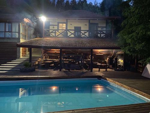 a swimming pool in front of a house at night at Рандеву in Slavske