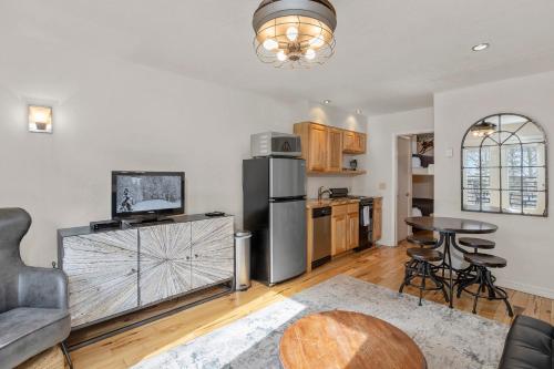 a kitchen with a stainless steel refrigerator and a table at River Location 2 blocks to lift 7 &to the Gondola in Telluride