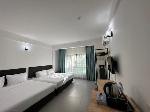 ein Hotelzimmer mit 2 Betten und einem TV in der Unterkunft ēRYA by SURIA Hot Spring Bentong in Bentong