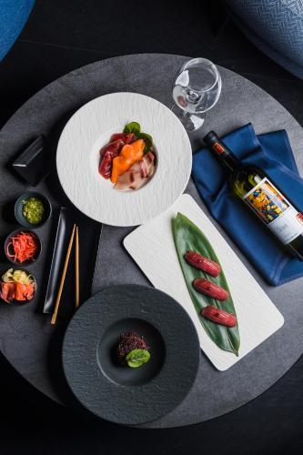 a table with two plates of food and a glass of wine at Hotel Meta Resort & Vine SPA in Szczyrk
