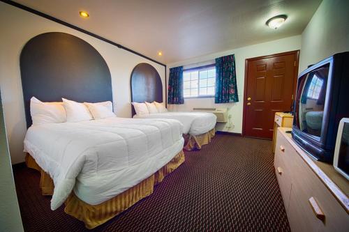 Habitación de hotel con 2 camas y TV en Budget Inn en The Dalles
