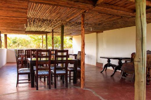 a dining room with wooden tables and chairs in a building at Mara Forest camp in Keekorok