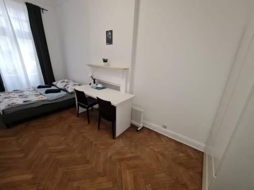 a room with a desk and a bed and a table and chairs at Fantastic Apartments - OK11 Room - E in Warsaw