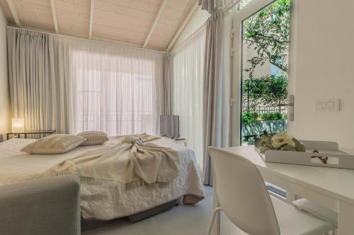 een slaapkamer met een bed, een bureau en een raam bij The Secret Garden in Varenna