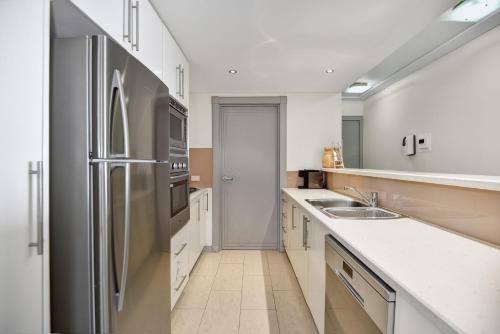 a kitchen with a stainless steel refrigerator at Sandy Cove Apartment The Entrance 24 in The Entrance