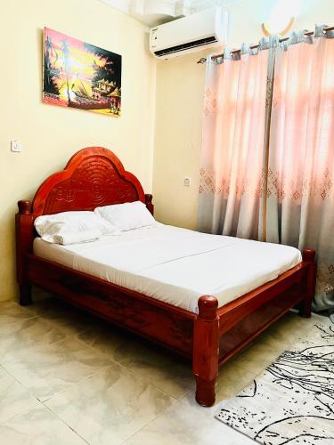 a bedroom with a bed with a red headboard at Nakupenda in Mazizini