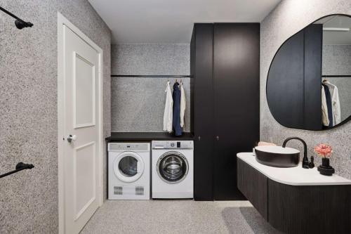 a laundry room with a washing machine and a sink at Adina Apartment Hotel Melbourne Flinders Street in Melbourne