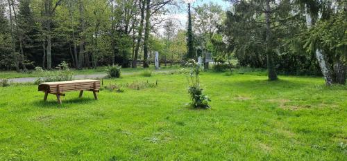 um banco de parque sentado num campo de relva em Chez Julie em Arnage