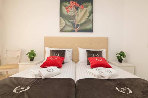 a bedroom with two beds with red pillows on them at MAapartmentsES Garden City in Playa Fañabe