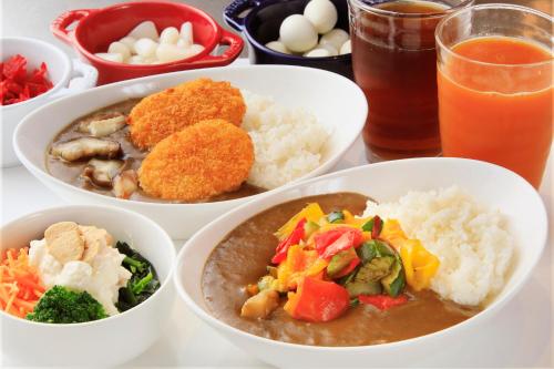 a table topped with bowls of food and rice at Quintessa Hotel Kokura Comic & Books in Kitakyushu