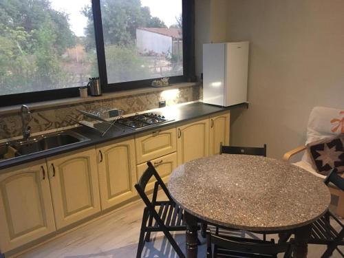 een keuken met een tafel, een wastafel en een koelkast bij La casa della Salvia con Piscina condivisa in campagna vicino al mare - Canestanco 18 in Santa Croce Camerina