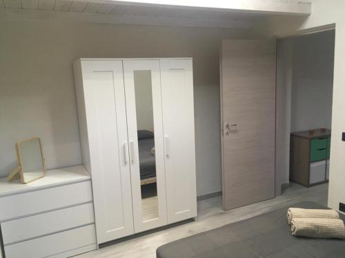 een kamer met een witte kast en een spiegel bij La casa della Salvia con Piscina condivisa in campagna vicino al mare - Canestanco 18 in Santa Croce Camerina
