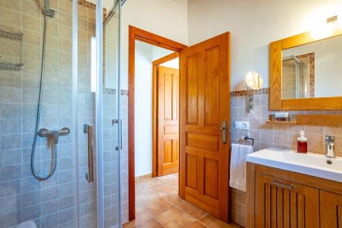 a bathroom with a shower and a sink and a mirror at Chalet Turó in Cala Santanyi