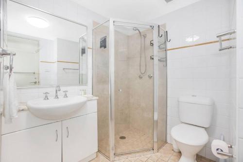 a bathroom with a shower and a toilet and a sink at Perfect Manly Retreat. in Sydney