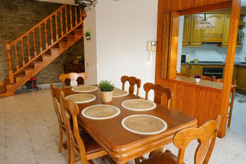 a dining room with a table with chairs and a staircase at Casa Nova, gaudeix del paisatge des de Vilamitjana in Vilamitjana