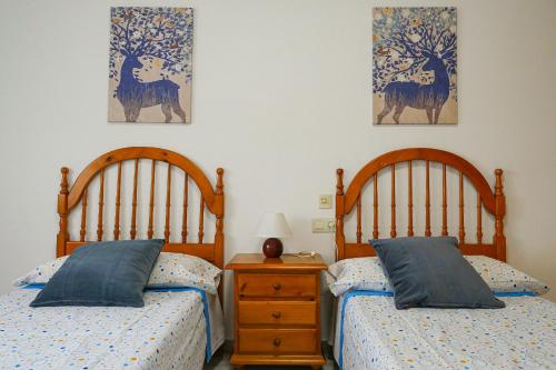 a bedroom with two beds and a night stand with a nightstand at Casa Nova, gaudeix del paisatge des de Vilamitjana in Vilamitjana