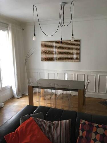 un salon avec une table et un canapé dans l'établissement Roland Garros /Boulogne Billancourt, à Boulogne-Billancourt