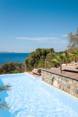 a swimming pool with the ocean in the background at Hôtel Marinca & Spa in Olmeto