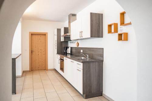 a kitchen with white cabinets and a sink at Falgerhof in Vollan