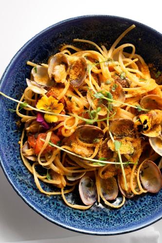 a blue bowl of food with noodles and mushrooms at Hôtel Marinca & Spa in Olmeto