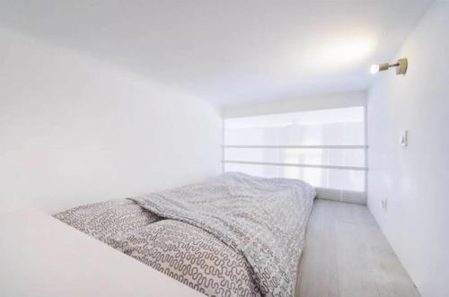 - une chambre avec des murs blancs et un lit avec une couverture dans l'établissement Sur Rbnb - Heros, à Marseille