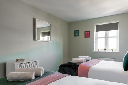 a bedroom with two beds and a mirror at Weekly & Monthly Rates! Stunning Home By Stansted Airport in Bishops Stortford