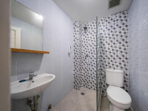 een badkamer met een toilet, een wastafel en een douche bij Cove Accordia Residence in Jakarta