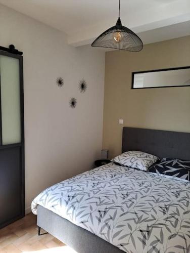 1 dormitorio con 1 cama y luz colgante en Chez Béatrice, en Saint-Jouan-des-Guérets