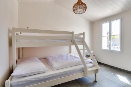 ein Schlafzimmer mit Etagenbetten in einem Zimmer mit Fenster in der Unterkunft Echapee familiale a l Epine in LʼÉpine