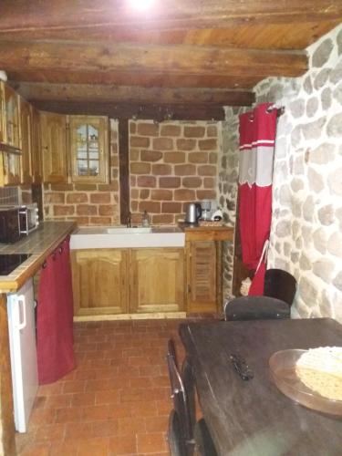 une cuisine avec des placards en bois et un mur en briques dans l'établissement BOUTIQUE BLEUE, à Craponne-sur-Arzon