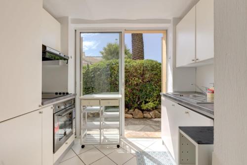 une cuisine avec des placards blancs et une grande fenêtre dans l'établissement Mont Boron Exclusive Apartment in Villa Belle Époque, à Nice