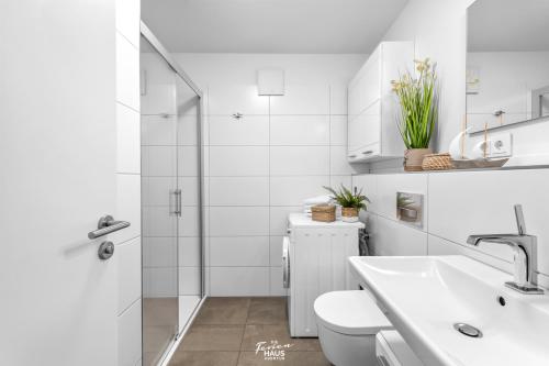 Baño blanco con aseo y lavamanos en Segler Nest, en Olpenitz