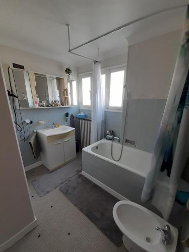 a bathroom with a tub and a toilet and a sink at Chambre d'hôte proche Paris in Épinay-sur-Seine