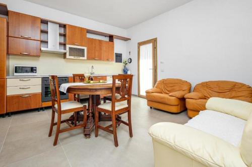 uma cozinha e sala de estar com uma mesa e um sofá em La Vecchia Posta em Telti