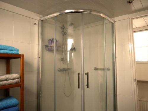 a shower with a glass door in a bathroom at Spacious homely house boat in Amsterdam
