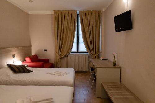 ein Hotelzimmer mit 2 Betten und einem roten Sofa in der Unterkunft Villa Lomellini in Montebello della Battaglia
