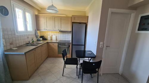 a kitchen with chairs and a table and a refrigerator at Feels like home studio in Néa Palátia