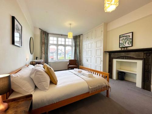 a bedroom with a large bed and a fireplace at Kim's 3 Bedroom House with Free On-Street Parking in Palmers Green