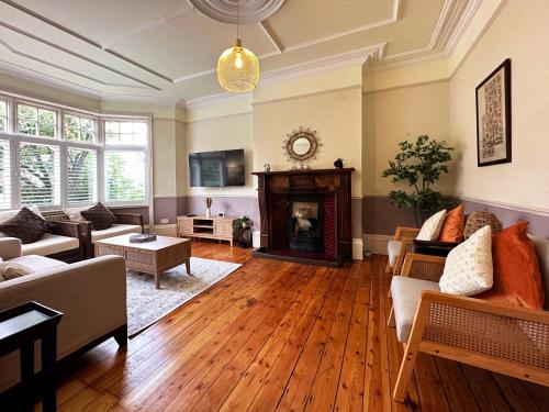 a living room with a fireplace and wooden floors at Kim's 3 Bedroom House with Free On-Street Parking in Palmers Green