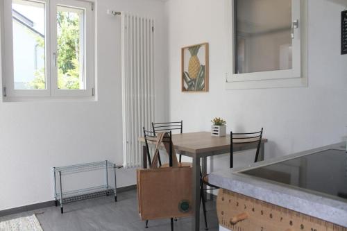 una cucina e una sala da pranzo con tavolo e sedie di NEB-THUN Studio am Thunersee a Thun