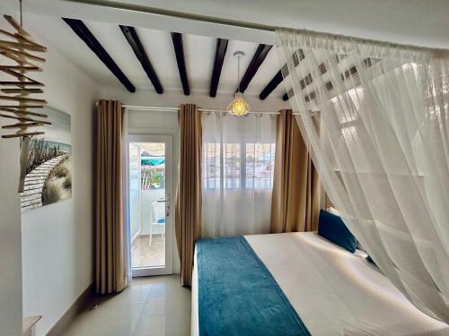 a bedroom with a canopy bed and a window at Mare Apartments Marbella in Marbella