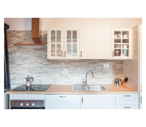 a kitchen with white cabinets and a sink at Apartment Toni in Sarntal