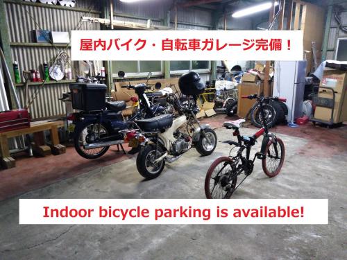 grupa motocykli i rowerów zaparkowanych w garażu w obiekcie Tateyama Wheels Guest House w mieście Tateyama