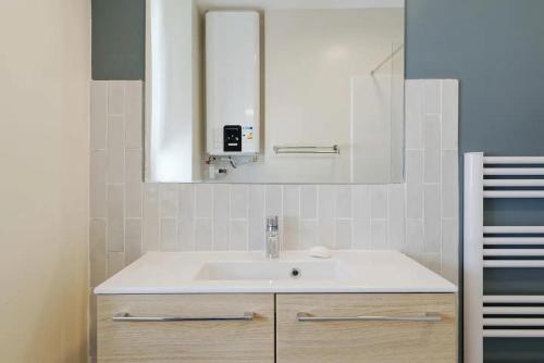 uma casa de banho com um lavatório e um espelho em [Gourjon 2] - T2 fonctionnel emplacement idéal Joliette em Marselha